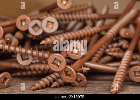 Keramikbeschichtete braune Holzschrauben mit flachem Kopf. Außenschrauben mit Vierkantkopf. Robertson-Deck-Schrauben. Holzschrauben mit grobem Gewinde. Stockfoto