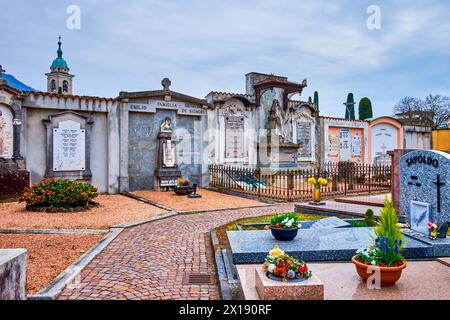 COLLINA D'ORO, SCHWEIZ - 18. MÄRZ 2022: Auf dem Friedhof von Sant'Abbondio befinden sich am 18. März in Collina Grabsteinreihen, die mit Skulpturen geschmückt sind Stockfoto