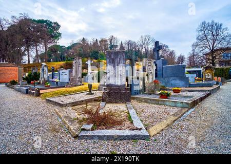 COLLINA D'ORO, SCHWEIZ - 18. MÄRZ 2022: Auf dem Friedhof von Sant'Abbondio befinden sich am 18. März in Collina Grabsteinreihen, die mit Skulpturen geschmückt sind Stockfoto