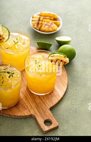 Gegrillte Ananasmargarita mit Limettenscheiben auf einem Serviertablett Stockfoto