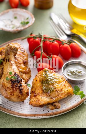 Gebratene Hähnchenstangen und Schenkel, serviert mit Pesto und Tomaten Stockfoto