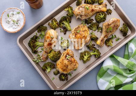 Hähnchenkeulen und Schenkel mit Brokkoli-Blechpfanne Abendessen oder Mittagessen mit Knoblauch und Kräutern gebraten und verzehrfertig Stockfoto