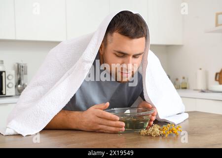 Junger Mann, der Dampf in der Küche einatmet Stockfoto