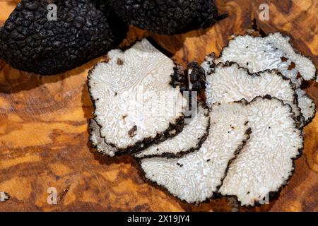 Scheiben italienischer schwarzer Sommertrüffel, leckere aromatische Pilze, Nahaufnahme Stockfoto