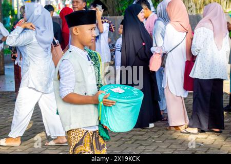 Indonesier sammeln Spenden von der Gemeinde, wenn sie Eid al-Fitr in der Moschee beten Stockfoto