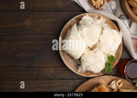 Östliche Süßigkeiten. Leckerer iranischer Paschmak und Tee auf Holztisch, flach gelegen. Leerzeichen für Text Stockfoto