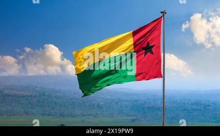 Die Fahne von Guinea-Bissau, flattert im Wind, isoliert, gegen den blauen Himmel Stockfoto