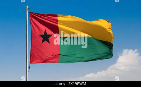 Die Fahne von Guinea-Bissau, flattert im Wind, isoliert, gegen den blauen Himmel Stockfoto