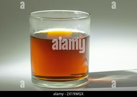 Brauner Zucker in einem Glas warmem Wasser gelöst Stockfoto