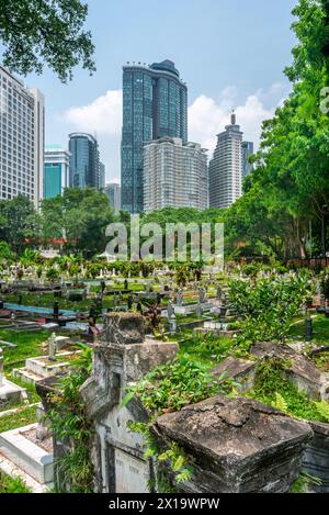 Versteckt in der Nähe von Jln Ampang und getrennt von Kampung Baru durch eine Autobahn ist eines der ältesten muslimischen Grabstätten von KL. Es ist beschattet von riesigen Banyans und Regen Stockfoto