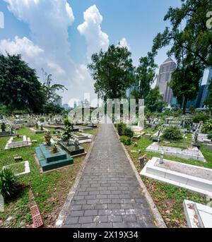 Versteckt in der Nähe von Jln Ampang und getrennt von Kampung Baru durch eine Autobahn ist eines der ältesten muslimischen Grabstätten von KL. Es ist beschattet von riesigen Banyans und Regen Stockfoto