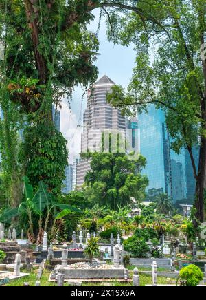 Versteckt in der Nähe von Jln Ampang und getrennt von Kampung Baru durch eine Autobahn ist eines der ältesten muslimischen Grabstätten von KL. Es ist beschattet von riesigen Banyans und Regen Stockfoto