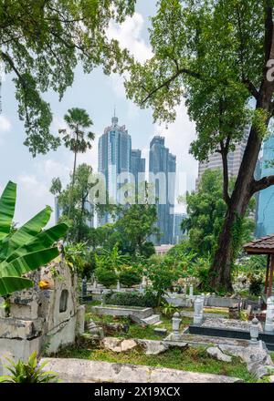 Versteckt in der Nähe von Jln Ampang und getrennt von Kampung Baru durch eine Autobahn ist eines der ältesten muslimischen Grabstätten von KL. Es ist beschattet von riesigen Banyans und Regen Stockfoto