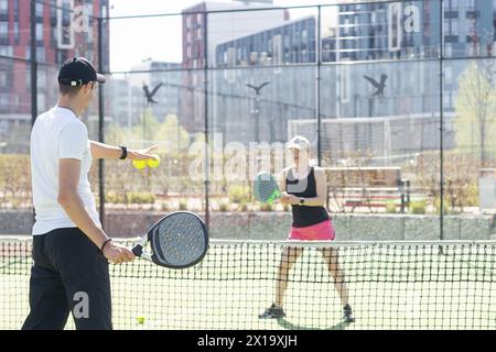 Porträt von zwei lächelnden Sportlern, die auf dem Padel-Platz im Freien mit Schlägern posieren - Padel-Spieler Stockfoto