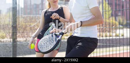 Sportpaare mit Padel-Schlägern, die auf dem Tennisplatz posieren Stockfoto