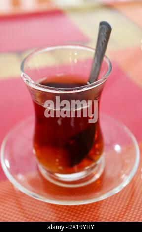 Heißer türkischer Tee in Tulpenform, isoliert auf buntem Tisch Stockfoto