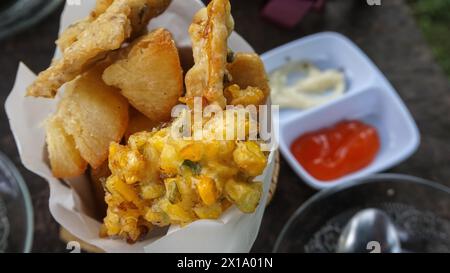 Verschiedene frittierte Speisen werden auf Tellern serviert, die in Indonesien berühmt sind, wie Maisbäckwan, Mendoan, gebratene Banane, gebratener Maniok und gebratener Tofu Stockfoto