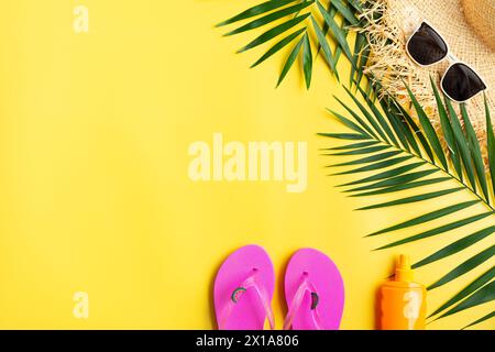 Urlaubsreiseplanung einfaches Thema der Strohhut Sonnenbrille Flipflops und Palmblätter auf einheitlichem gelbem Hintergrund flach mit Kopierraum Stockfoto