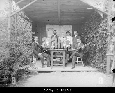 Schrammel-Musik, vier Männer mit Musikinstrumenten in einer großen Laube um einen Tisch sitzend, dahinter stehen zwei Männer und eine Frau, einer der Männer Otto Schinkele. Fotografie, 1890 - 18900101 PD1165 - Rechteinfo: Rights Managed (RM) Stockfoto