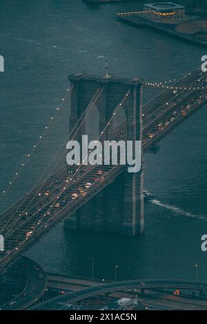Brooklyn Bridge, New York von oben auf einem Hubschrauberrundflug in der Dämmerung mit Fahrzeugverkehr bei eingeschalteten Ampeln. Stockfoto
