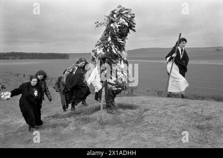 New Age-Hippie-Druiden und eine Greenman-Figur spazieren um einen der kreisrunden Henge-Ufer von Avebury. Avebury ist ein neolithisches Henge-Denkmal mit drei Steinkreisen, umgeben von einem riesigen hohen Ufer. Es ist einer der größten megalithischen Steinkreise der Welt. Avebury, Wiltshire, England, 1996 1990er Jahre, Großbritannien HOMER SYKES Stockfoto