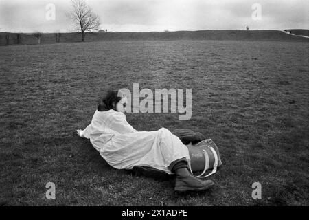 Avebury, Wiltshire, England 1996. Avebury ist ein neolithisches Henge-Denkmal mit drei Steinkreisen. Bardiker und Songwriter Steve Andrews. Die riesige Henge Bank in der Ferne. 1990s UK HOMER SYKES meine Ref. 18/4989/ Stockfoto