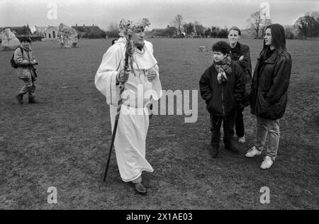 Überraschte Gruppenmenschen, Touristen, die einen älteren Druiden in Gewändern und einer Krone aus stechpalmenblättern sehen und sein Büro tragen. Mitglieder des New Age British Druid Ordens treffen sich im Avebury Stone Circle Wiltshire, um einen Druidensegen zu feiern. HOMER SYKES AUS DEN 1996 1990ER JAHREN Stockfoto