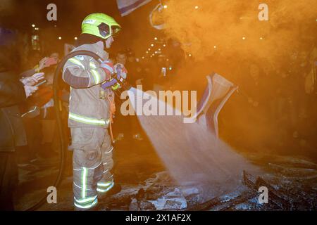 Tel Aviv, Israel. März 2024. Ein Feuerwehrmann, der ein Feuer handhabt, das von Demonstranten ausgelöst wurde. Israelische Demonstranten treffen sich zu zwei Demonstrationen in Tel Aviv. Eine Forderung nach Wahlen, um Benjamin Netanjahus Regierung zu ersetzen, und behauptet, sie sei verantwortlich für den größten Misserfolg in der Geschichte Israels am 7. Oktober. Die zweite ist eine Kundgebung, um die Familien der Geiseln zu unterstützen und ihre sofortige Freilassung aus Gaza zu fordern, wo 133 israelische Zivilisten immer noch von Hamas-Terroristen gefangen gehalten werden. Die beiden Veranstaltungen finden in unmittelbarer Nähe und zeitlicher Nähe statt, und die meisten Demonstranten nehmen an beiden Teil. (Guthaben Stockfoto