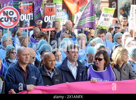 Shadow Health Secretary Andy Burnham marschiert mit Demonstranten während eines marsches vor der Konservativen Konferenz 2013 in Manchester Central. Stockfoto