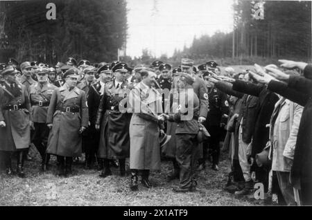 Adolf Hitler am Walserberg, Hitler schüttelt sich die Hand mit einem Arbeiter, vor (oder nach) dem ersten Schnitt mit einem Spaten für die Autobahn neben ihm zahlreiche Offiziere direkt neben Menschen mit Nazi-Gruß, 7.4.1938 - 19380407 PD0017 - Rechteinfo: Rights Managed (RM) Stockfoto