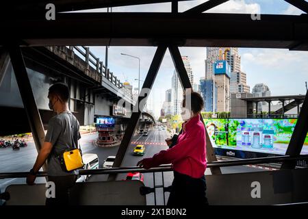 Fußgänger, die einen Spaziergang entlang des Skytrain-Bahnhofs Sala Daeng BTS in der Silom-Gegend von Bangkok, Thailand, Unternehmen. Die Straße darunter ist Rama IV Stockfoto