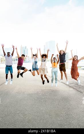 Glückliche multirassische Menschen springen zusammen im Freien Stockfoto