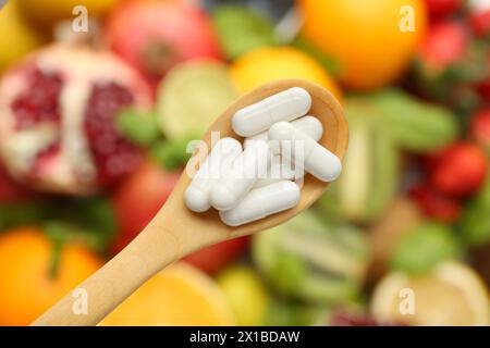 Vitaminpillen im Löffel über frischem Obst, Blick von oben Stockfoto