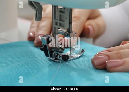 Näherin arbeitet mit Nähmaschine in Innenräumen, selektiver Fokus Stockfoto