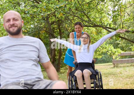 Drei Freunde genießen einen sonnigen Tag im Freien, eine Person benutzt einen Rollstuhl und strahlt Glück und Inklusion aus. Stockfoto