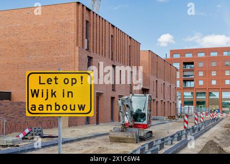 Schild mit dem niederländischen Text für „Achtung - Wohngebiet im Bau“ vor neuen Einfamilienhäusern in Lent Nijmegen, Niederlande Stockfoto