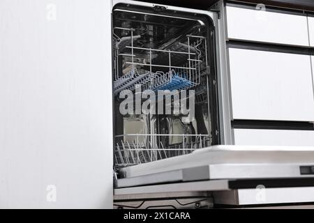 Eingebauter Geschirrspüler mit offener Tür im Innenbereich. Haushaltsgerät Stockfoto