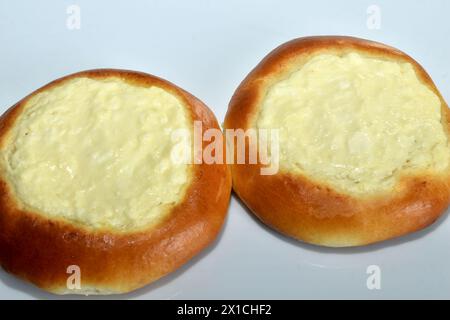 Es gibt Brötchen und Käsekuchen auf dem Tisch, mit Hüttenkäse auf der Oberseite und braunen Seiten, Blick von oben. Stockfoto