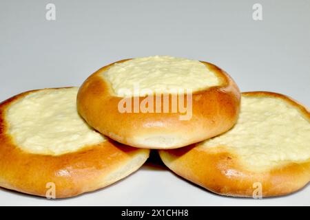 Es gibt Brötchen und Käsekuchen auf dem Tisch, mit Hüttenkäse auf der Oberseite und braunen Seiten. Stockfoto