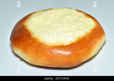 Auf dem Tisch steht ein Brötchen, ein Käsekuchen mit Hüttenkäse. Gesunder Lebensstil. Leckeres Frühstück. Stockfoto