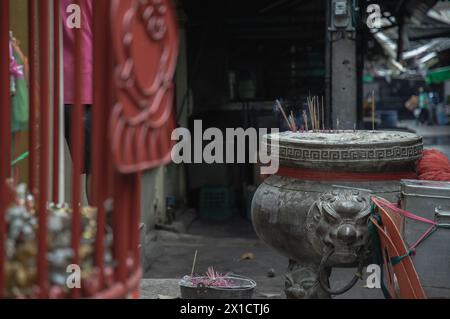 Bangkok, Thailand - 11. April 2024 - mit weißem Rauch verbrannte Räucherstäbchen mit Drachen-Skulptur vor dem alten Schrein. Platz für Stockfoto