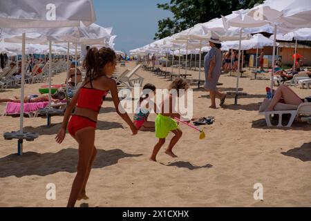 Kinder spielen an einem Sandstrand und genießen ihren Sommer. Es ist ein schöner sonniger Tag am Schwarzen Meer Stockfoto