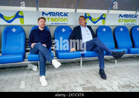 Darmstadt, Deutschland. April 2024. Fußball: Bundesliga, SV Darmstadt 98 Pressekonferenz, Merck-Stadion Böllenfalltor. Paul Fernie (l), neuer Sportdirektor beim SV Darmstadt 98, und Rüdiger Fritsch, Präsident des SV Darmstadt 98, sitzen auf der Spielerbank im Stadion. Quelle: Uwe Anspach/dpa/Alamy Live News Stockfoto