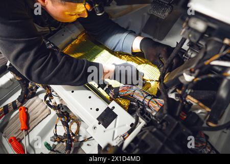 Prozess der Installation von Kfz-Schallschutzmaterial im Kfz-Service Stockfoto