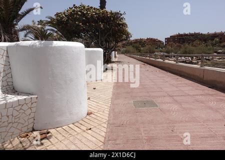 Palm-Mar, Teneriffa, 16. April 2024 - die mit anti-touristischen Graffitis bedeckten Bänke am Meer haben eine neue Farbe auf den Slogans in Palm-Mar, Teneriffa. - Anti-Touristen-Graffiti, die an den Wänden des Badeortes Palm-Mar im Süden der Insel Teneriffa gekrabbelt wurden, wurden von Beamten überstrichen, die versuchen, die kleine Stadt als "touristisch freundlich" zu bezeichnen. Mehrere Botschaften wurden vor Wochen auf Mauern und Bänken gesprüht; allerdings deckt nun neue weiße Farbe die betroffenen Gebiete ab, und ein Slogan mit der Aufschrift „durchschnittliches Gehalt auf den Kanarischen Inseln 1,200E“ wurde nun mit grauem p überzogen Stockfoto