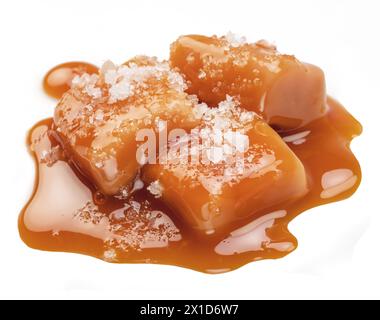 Karamellbonbons bedeckt mit Schmelzkaramell und Salzkristallen isoliert auf weißem Hintergrund. Stockfoto