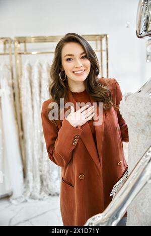 Eine junge Braut erkundet ein Kleiderregal und denkt über ihren Hochzeitstag-Look nach. Stockfoto