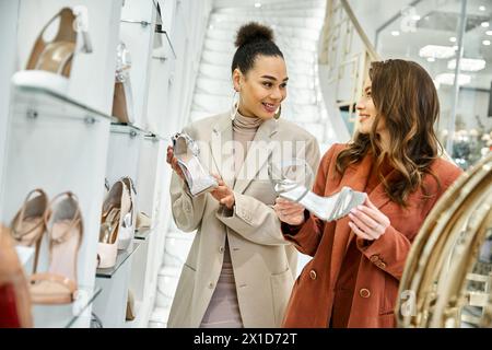 Zwei Frauen, eine junge, schöne Braut und ihr bester Freund, erkunden die Schuhoptionen in einem lebhaften Schuhgeschäft. Stockfoto