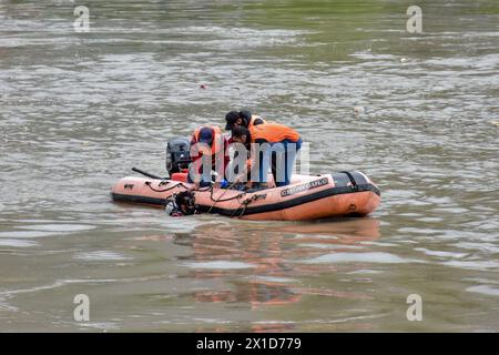 Retter der National Disaster Response Force (NDRF) suchen nach einem Boot, das Menschen, einschließlich Kinder, transportiert, die im Fluss Jhelum am Stadtrand von Srinagar gekentert sind. Ein Boot mit einer Gruppe von Menschen ist in einem Fluss gekentert und ertränkt sechs von ihnen. Die meisten Passagiere waren Kinder auf dem Weg zur Schule, und Retter suchen nach den Vermissten. Stockfoto