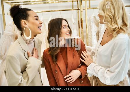 Eine junge, schöne Braut, ihre Mutter und beste Freundin stehen zusammen in einem Laden und suchen nach Hochzeitsartikeln. Stockfoto